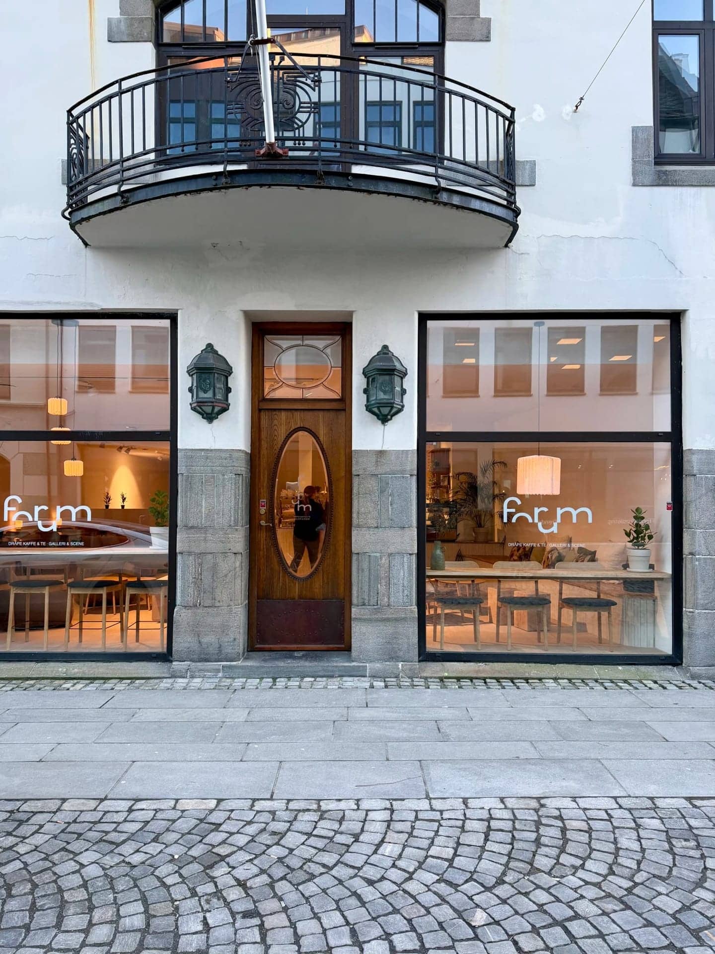 Forum sett fra brosteinen i Kongensgate om kvelden, med lys i vinduene