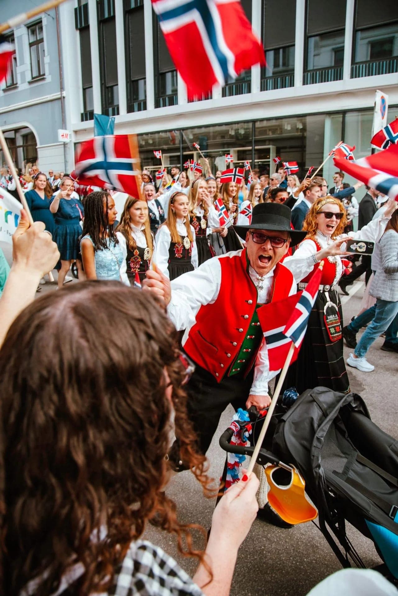 17. mai-tog gjennom Ålesund sentrum, med flagg og bunader