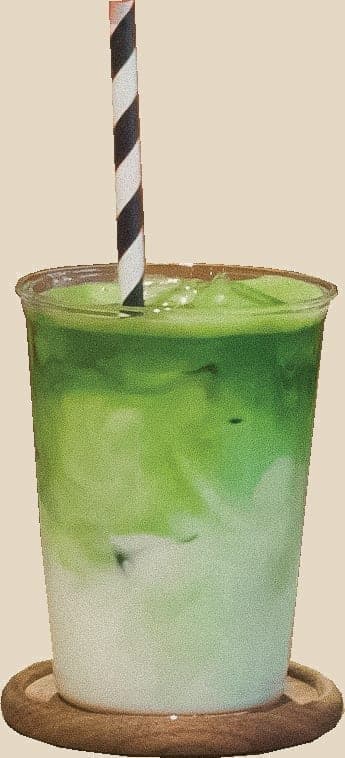 Ismatcha i et klart glass, med stripete sugerør og tre lag grønt over melk